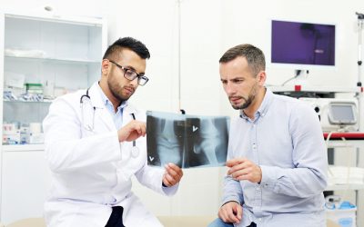 Radiologist and young man discussing x-ray images of joints